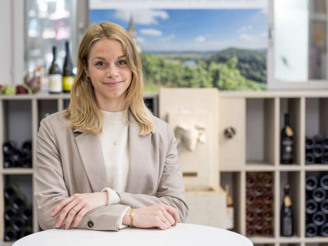 Portrait Salome Dällenbach. Sie hat blonde Haare, trägt einen weissen Wollpulli und einen beigen Blazer.