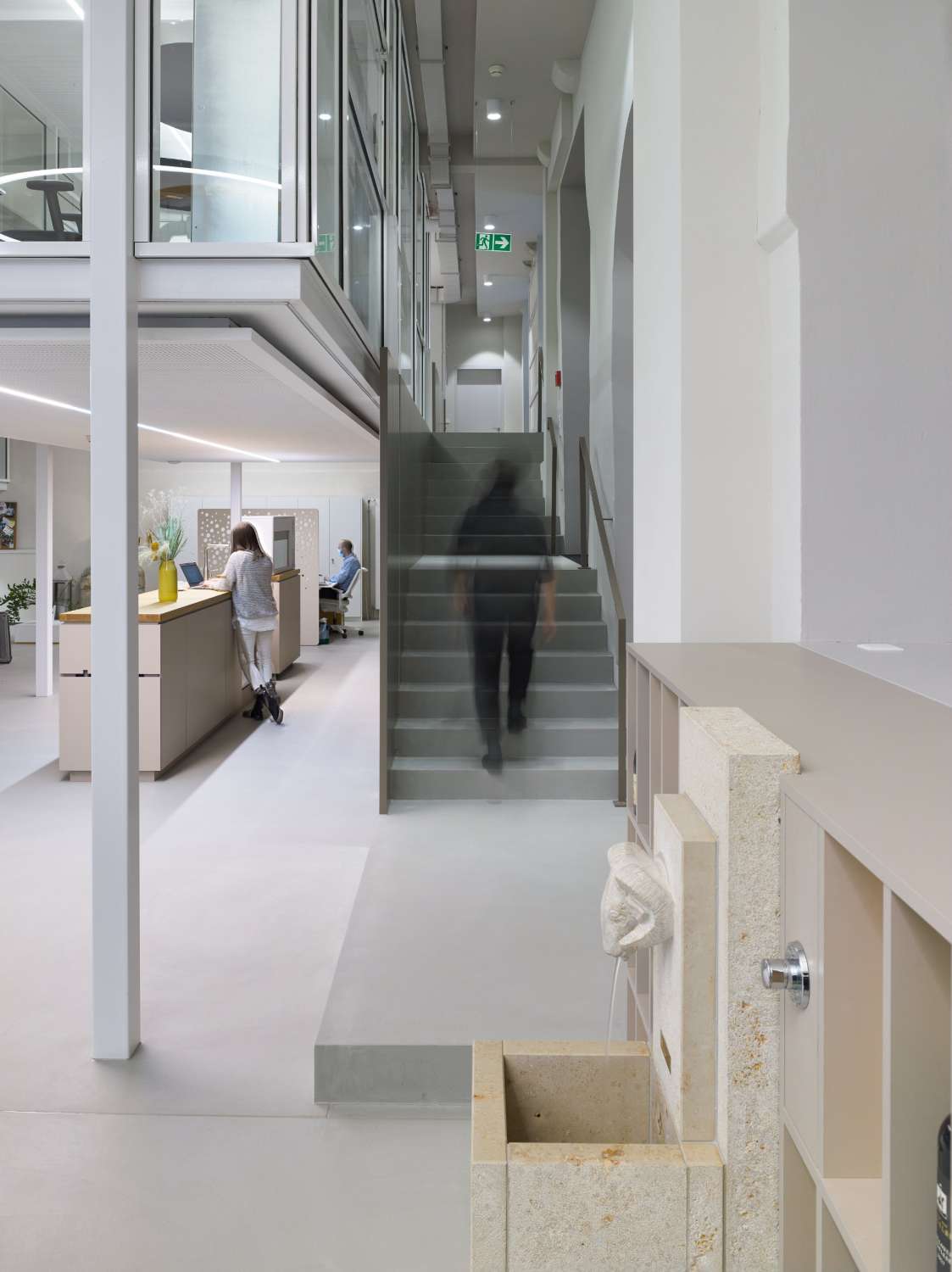 Räumlichkeiten des Visitor Centres Schaffhausen mit Theke, Brunnen und Treppe.